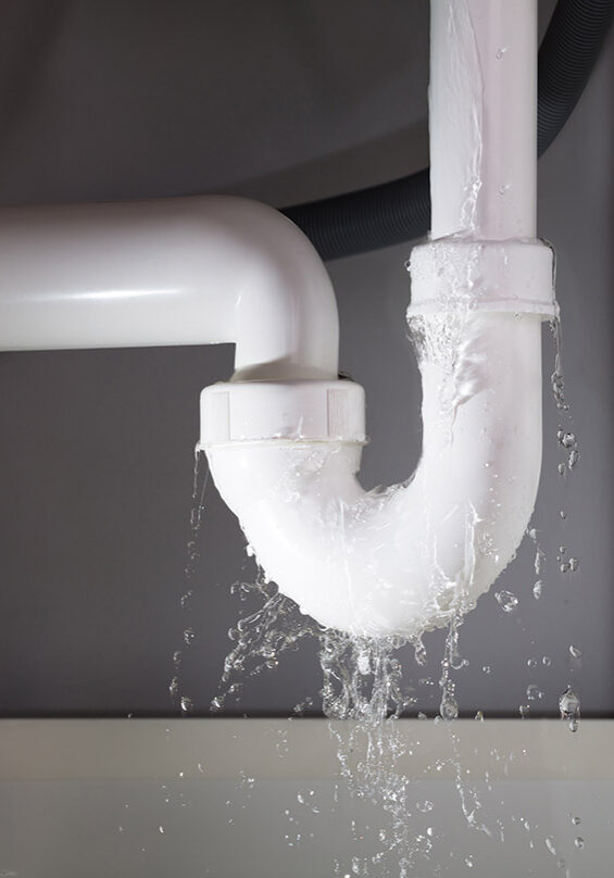 Plumber fixing burst pipe under sink